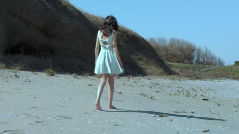 하얀 드레스를 입은 예쁜 소녀가 해변에서 산책-5
