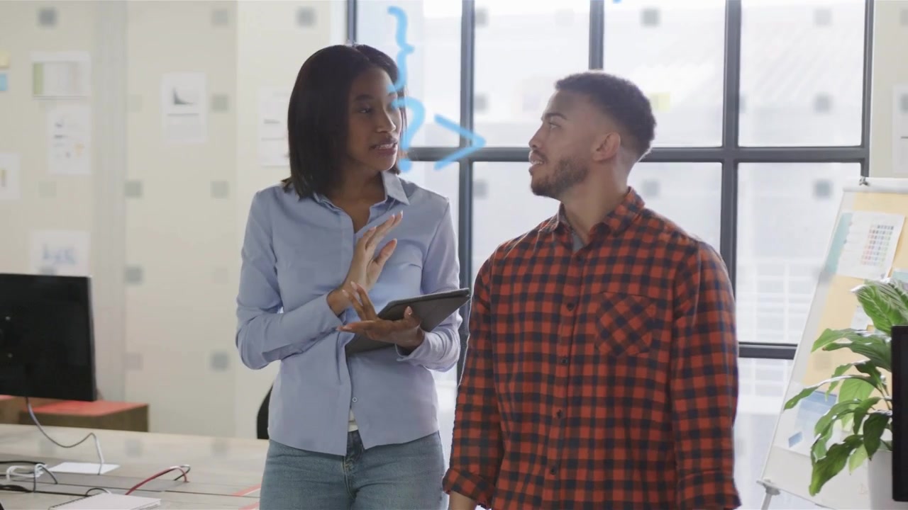 Woman tapping tablet and starting blue code overlay, coworkers discussing tech project near screens