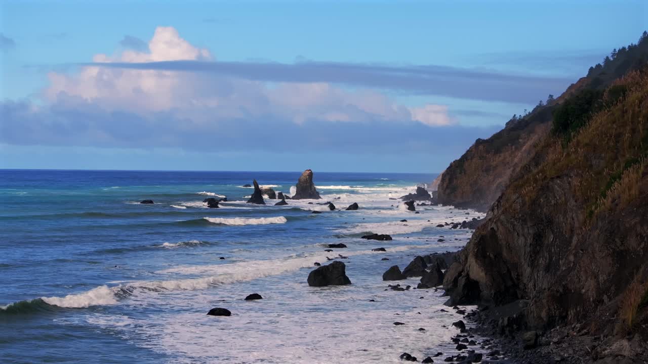 Shoreline Pacific Coastal Highway 1 DeHaven Westport Fort Bragg aerial drone California rugged Coastline blue sky surf waves crashing boulder rocks mountain side clouds Pacific Ocean static motion
