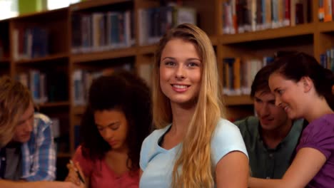 student smiling at camera in library