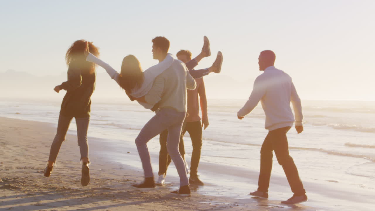 친구 들 의 그룹 이 함께 겨울 해변 에서 재미 를 느끼고 있다