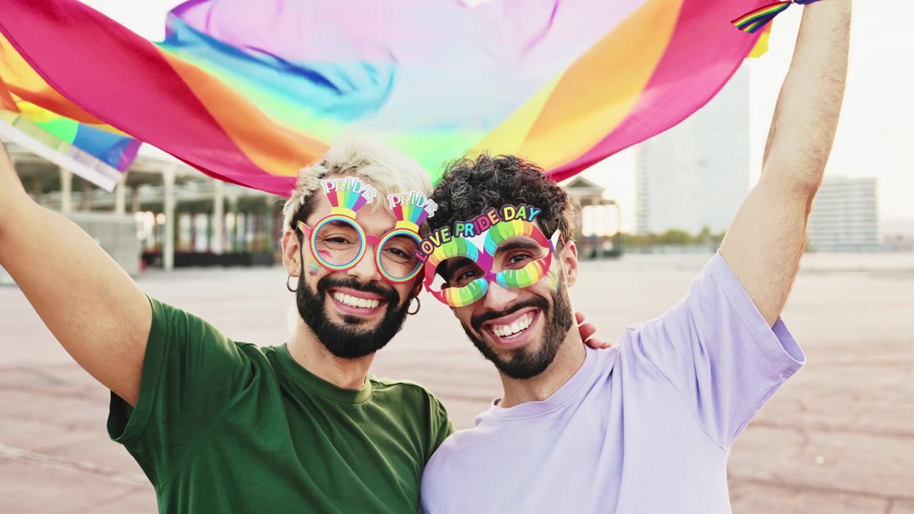 Joyful Gay Couple with Rainbow Flag and Pride Glasses