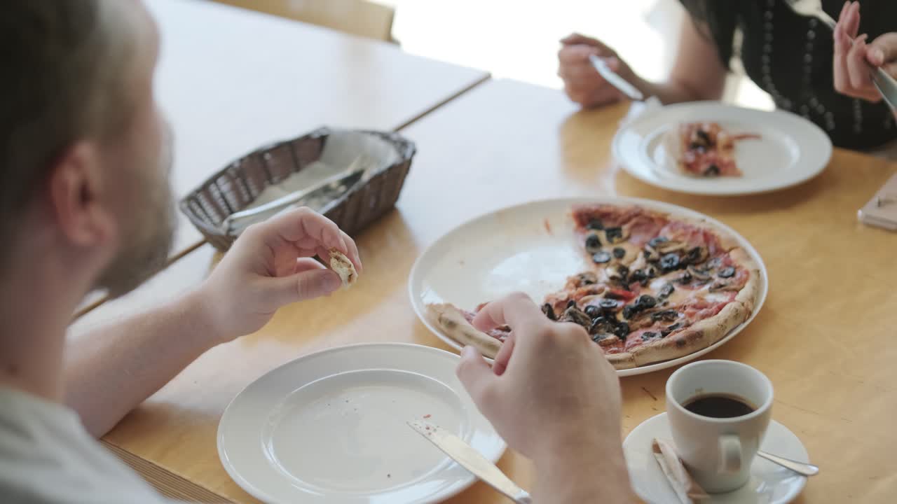 una pareja comiendo pizza en un restaurante.