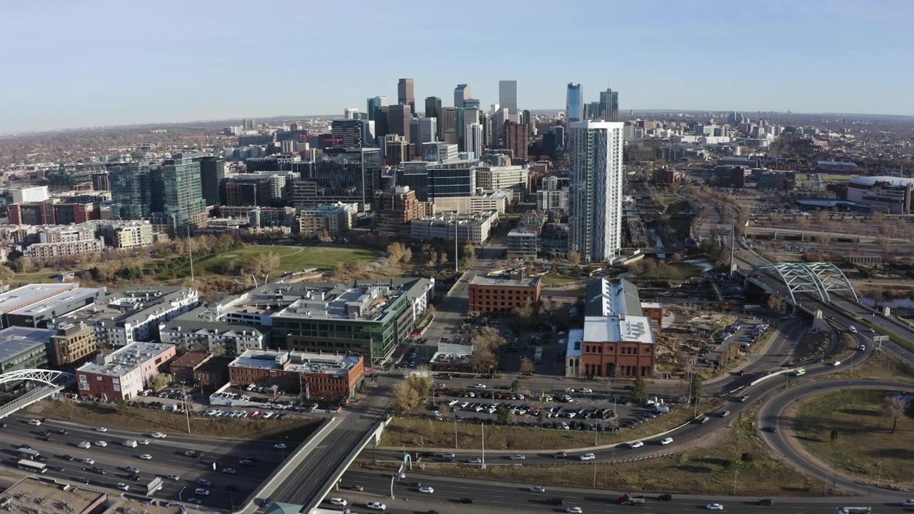 Ripresa aerea con drone del traffico cittadino di Denver, skyline, lento zoom a uscire, mezzogiorno