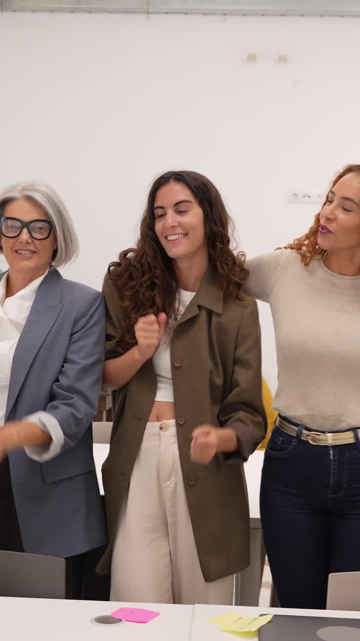 Equipa de negócios feliz e diversificada comemora o sucesso no escritório moderno