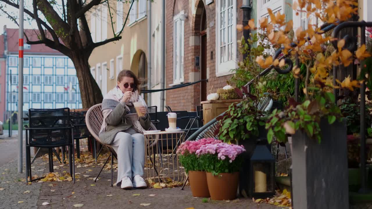 Woman enjoying a latte in a cozy autumn cafe