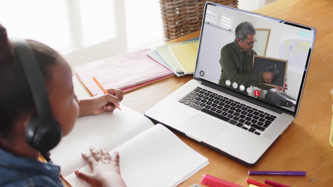 chica afroamericana usando una computadora portátil para una lección en línea con un profesor masculino biracial en la pantalla