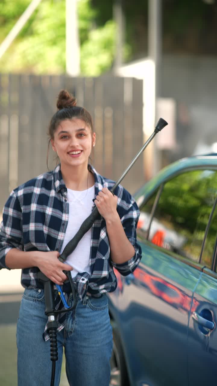 mujer lavando un coche azul en un lavado de coches