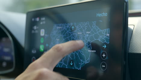 man's finger touching and scrolling around gps navigational map on a car screen - finding location