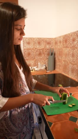 mujer cortando pepinos en la cocina
