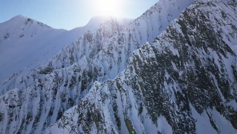 the camera flies around big snow-covered white mountain with big cliffs
