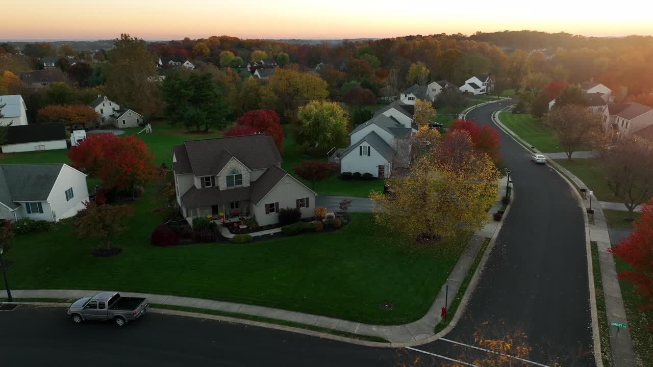 Vue aérienne basse de maisons individuelles dans un nouveau lotissement résidentiel au coucher du soleil.