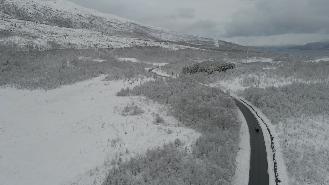 노르웨이 의 구름 이 가득 한 하늘 아래 눈 으로 인 숲 속 의 도로 의 풍경 - 공중 정적 촬영