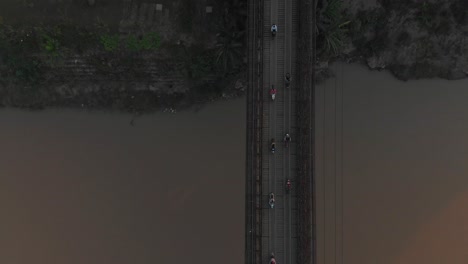 Top-down-view-of-old-bridge-over-mekong-river-at-Loas,-aerial