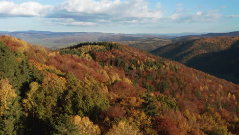 reverse aerial dolly over foothills covered with beautiful autumn foliage