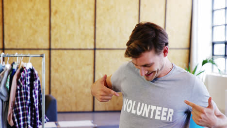 smiling volunteers pointing to t-shirt