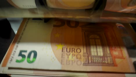 euro 50 banknotes being processed by a counting machine