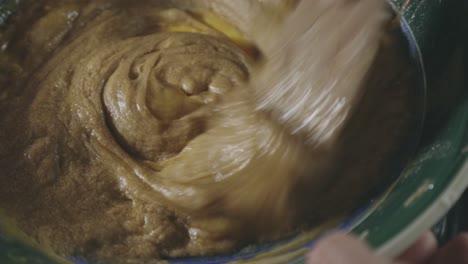 mixing cookie batter and eggs in a bowl - close up