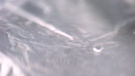 water droplets creating puddle on surface close-up