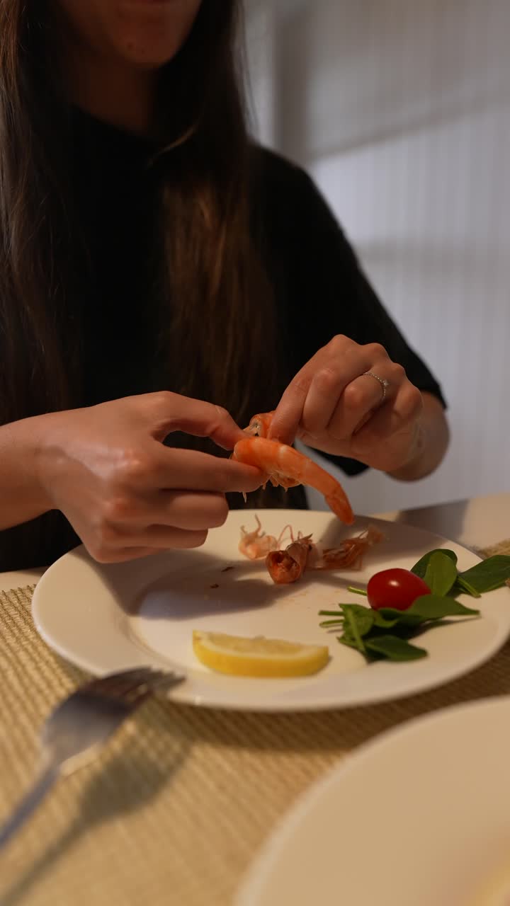 una mujer comiendo camarones.