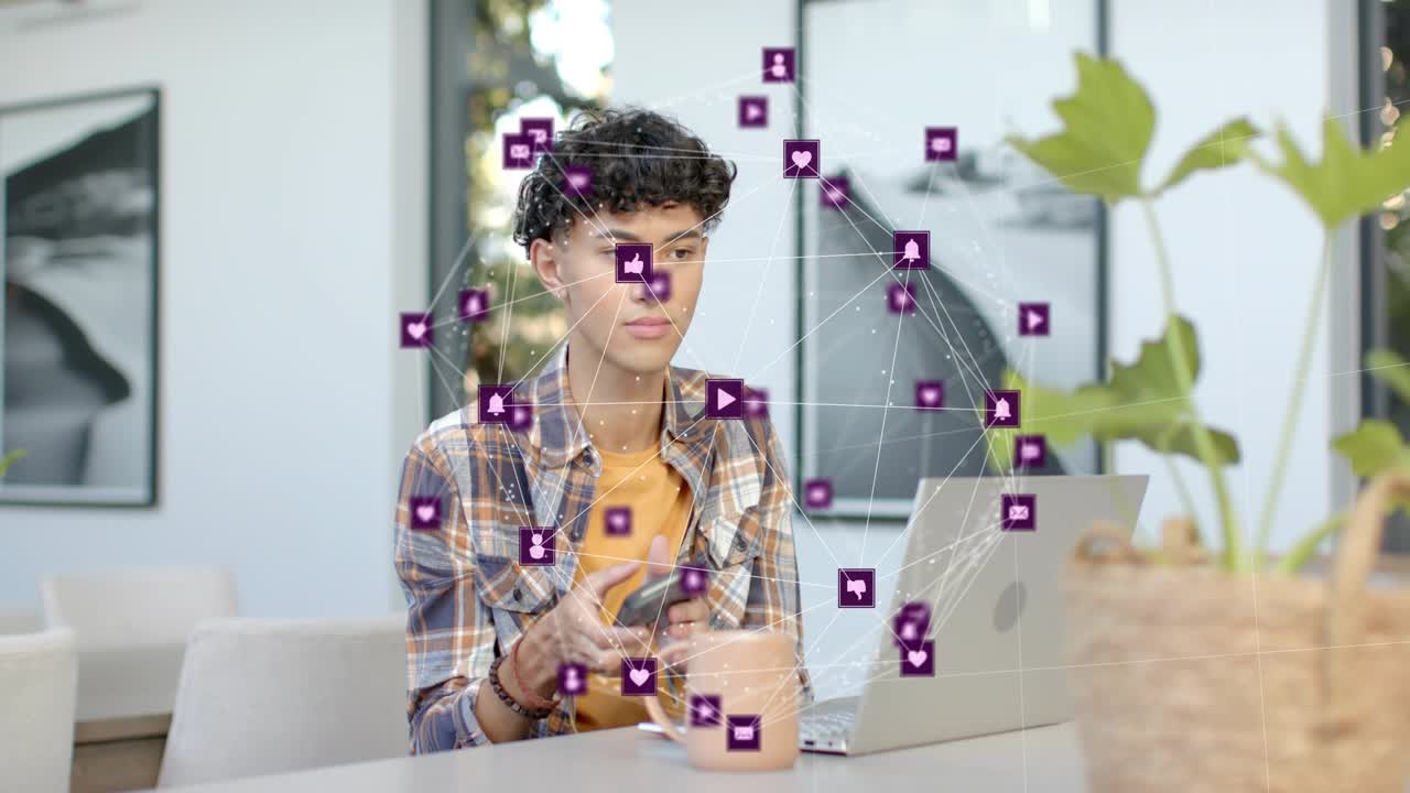 Man sitting at table laptop purple tech icons growing floating around head driving phone scrolling