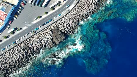aeriel drone footage at garachico - caleton (tenerife) next to the blue ocean as the waves hit the rocks in the water