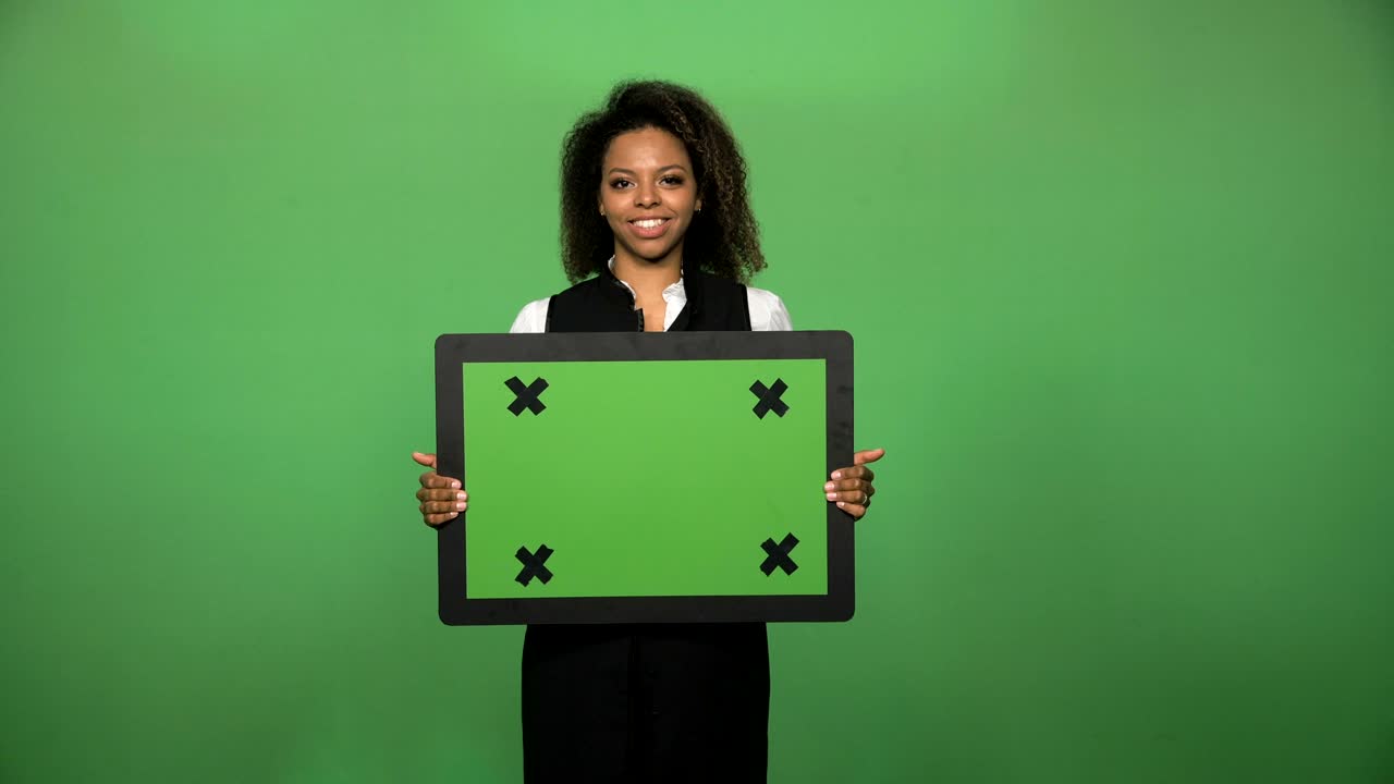 una mujer de negocios sonriente y confiada con una tabla de chromakey