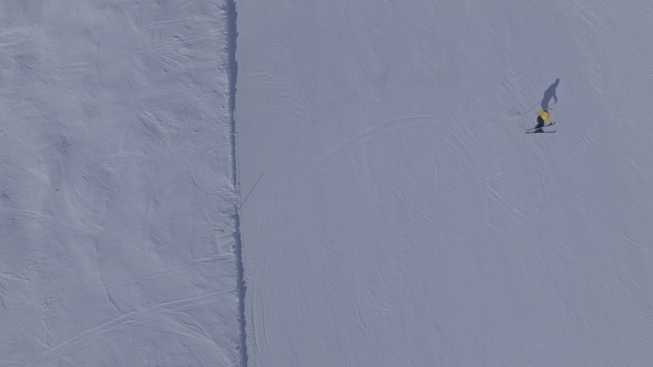 Sci alpino di alta performance in carving su piste battute a Verbier Bruson e nella Val de Bagnes, filmato con drone e follow cam in una giornata invernale serena e soleggiata, che mostra uno sci veloce, dinamico e divertente