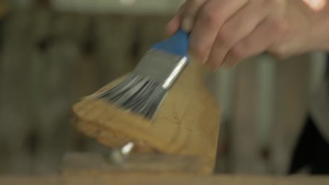 brushing danish oil onto a handmade canoe paddle