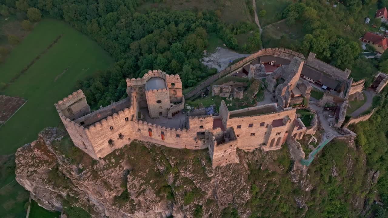 Vista aerea del Castello di Beckov che si erge imponente sopra campi rigogliosi.