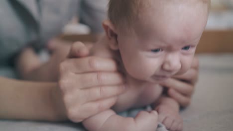 baby-with-blond-hair-lies-on-stomach-on-changing-table