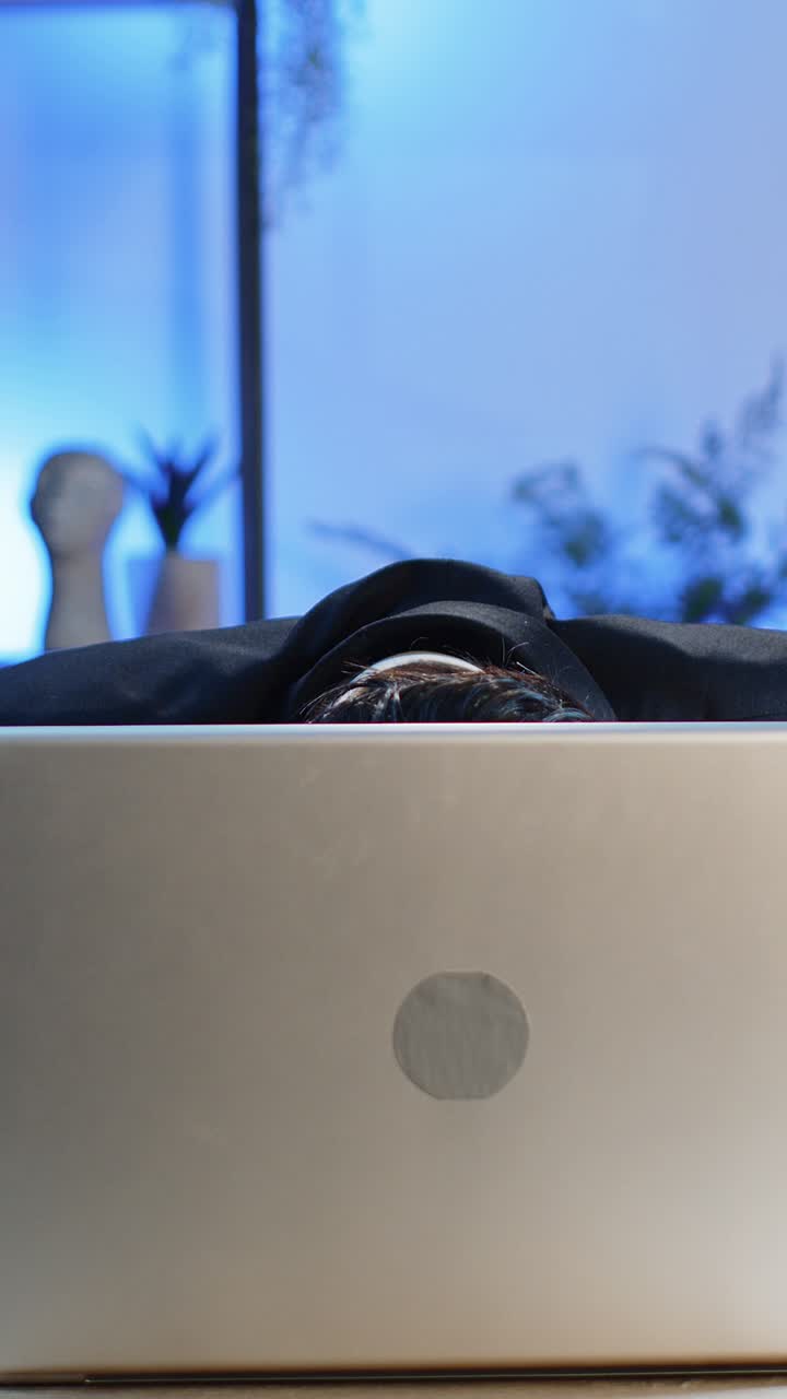Office businessman hiding behind laptop computer making funny silly face fooling around disrespect