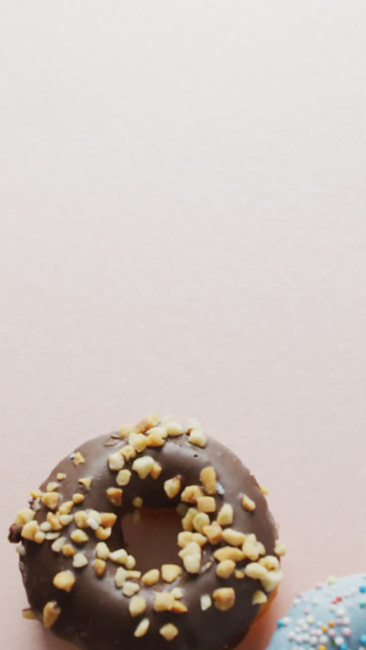 video de rosquillas con glaseado y una taza de café sobre un fondo rosa