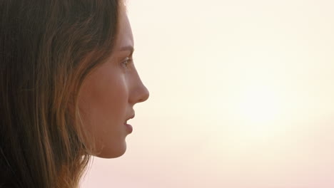 close up portrait of beautiful woman enjoying calm seaside at sunset exploring spirituality looking up praying contemplating journey relaxing on beach