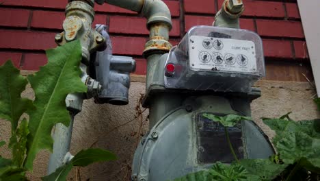 a natural gas meter on the side of a regular home in the suburbs running and measuring the gas usage