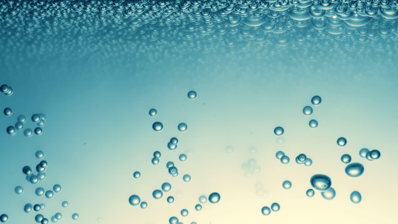 Many water bubbles in blue water close up, abstract water wave with bubbles in slow motion.