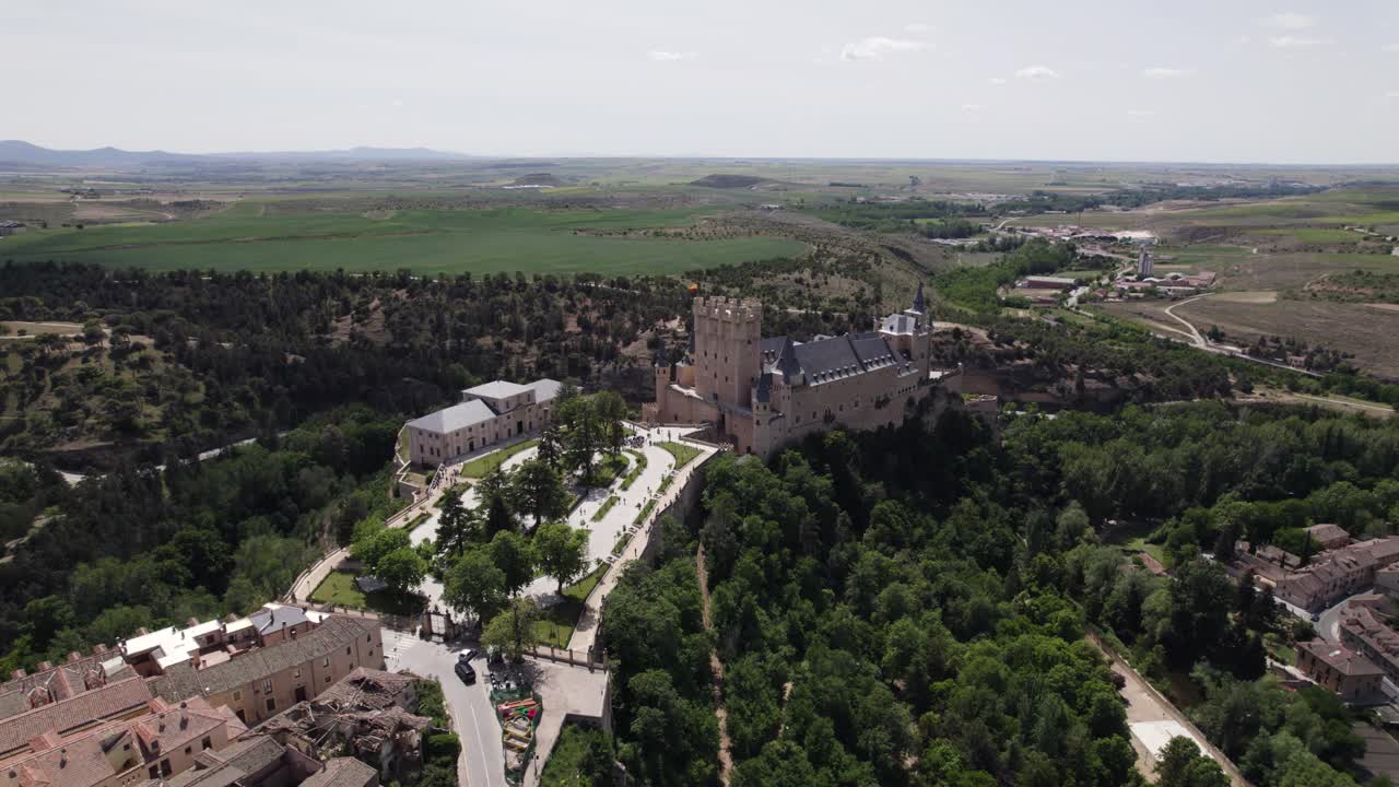 Aerial view orbiting Alcazar of Segovia medieval castle in the picturesque countryside cityscape of Castile and Le&oacute;n skyline
