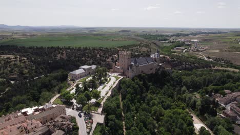 Aerial-view-orbiting-Alcazar-of-Segovia-medieval-castle-in-the-picturesque-countryside-cityscape-of-Castile-and-León-skyline