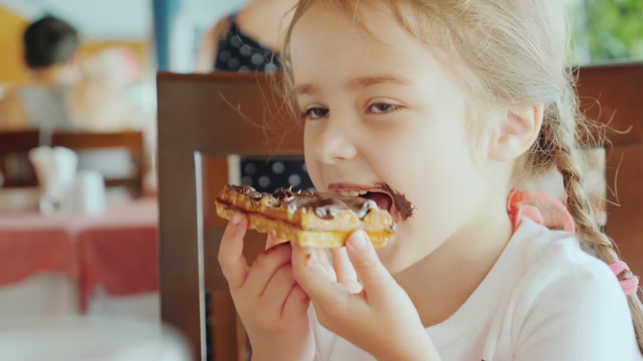 The Little Sweetheart Was All Smeared With Chocolate The Child Is Sitting In A Restaurant And Eating