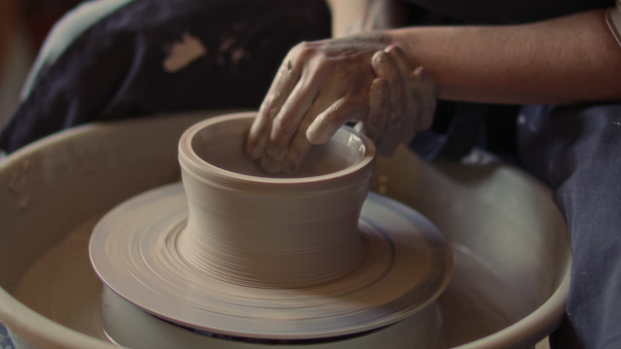 Young Female Ceramics Artist Forming Clay Vessel on Pottery Wheel
