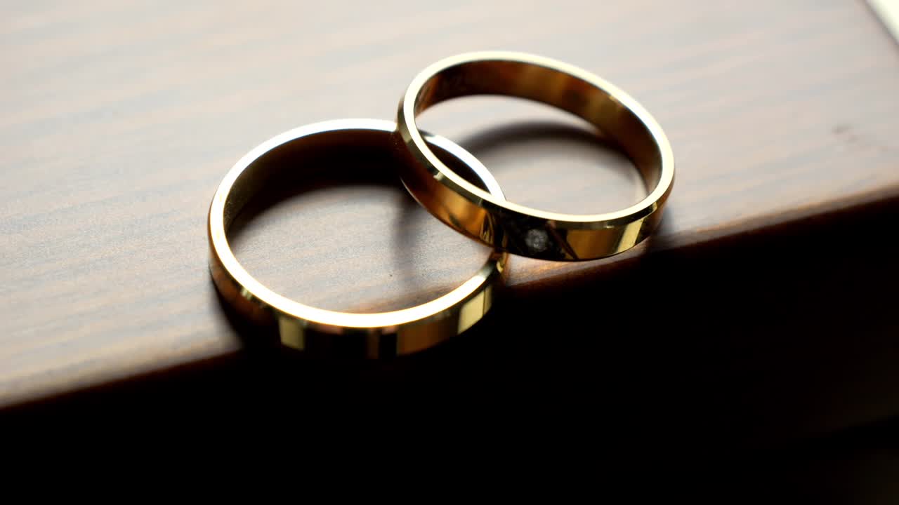 Two golden wedding rings, one adorned with a precious gemstone