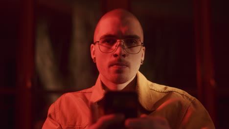 man using mobile phone in a dimly lit room