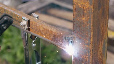 closeup fixing metal fence with welding tool at house