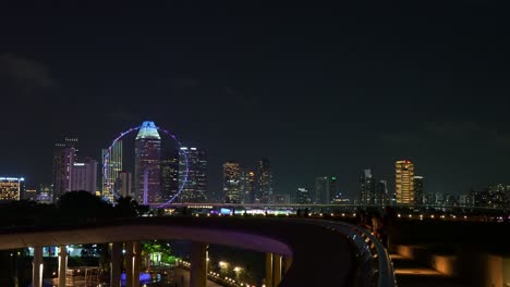 static shot capturing the activities in marina barrage's rooftop park and illuminated singapore downtown cityscape on the skyline at night