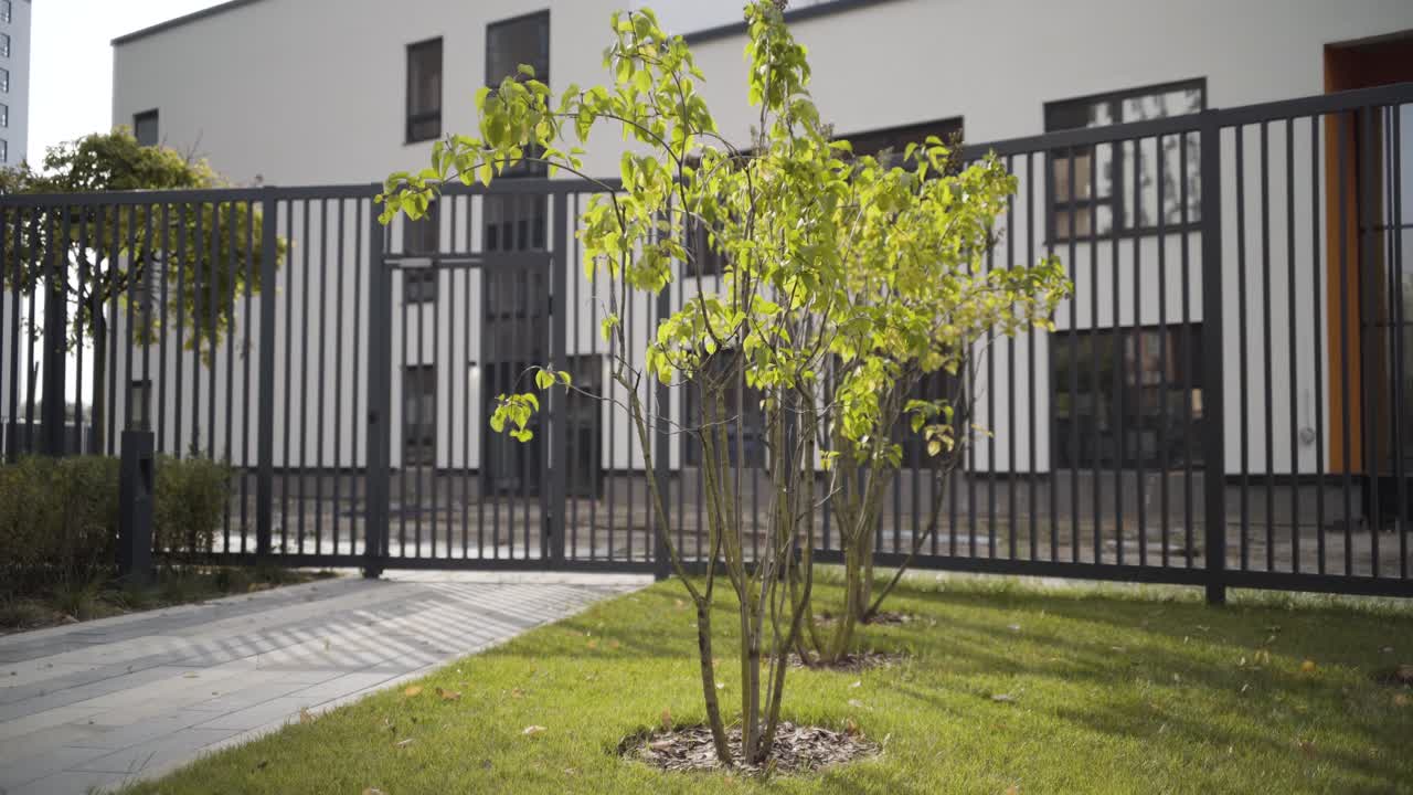 Esterno moderno di edificio con alberi e recinzione