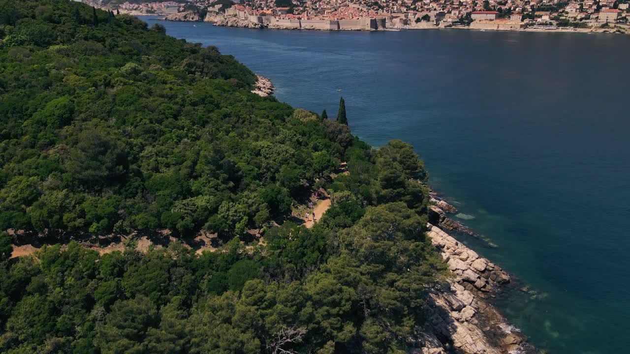 Drone aereo che sorvola l'isola di Lokrum con escursionisti su un sentiero