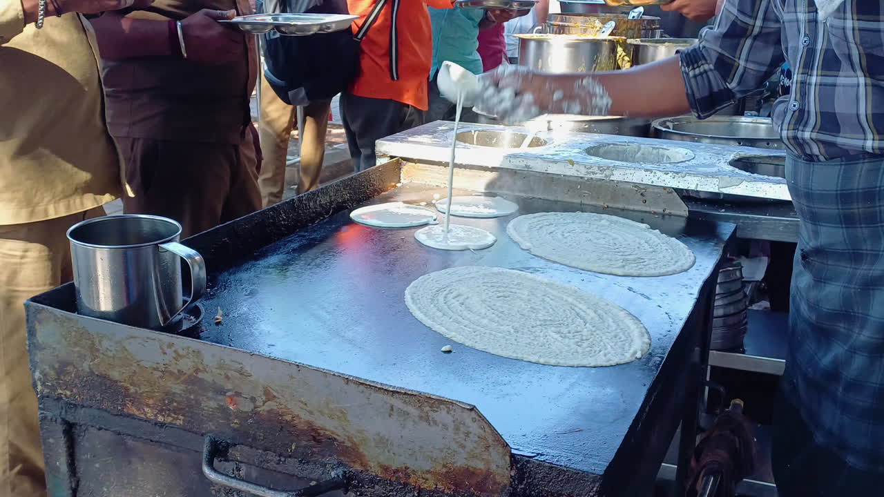 el cocinero haciendo el masala dosa en la tienda de comida callejera al aire libre