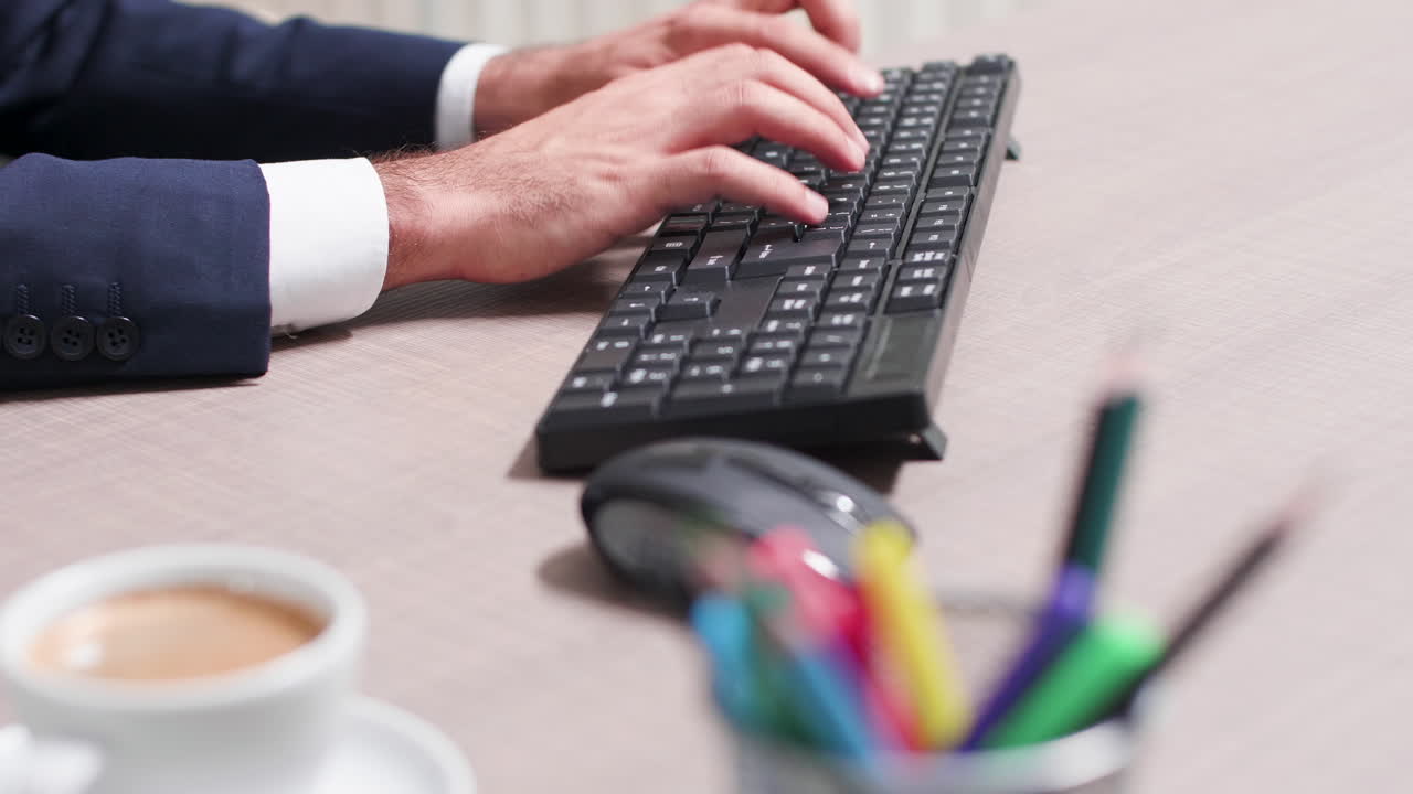 Man working at desk with computer and coffee