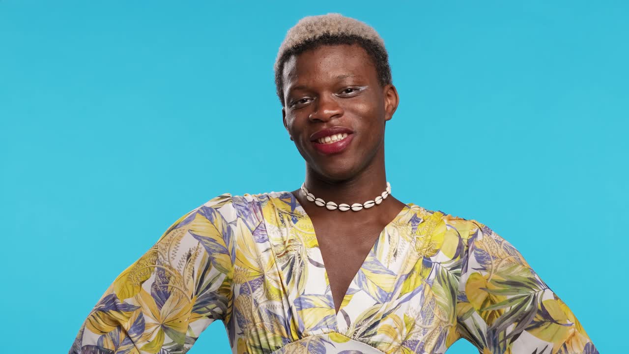 Sebevědomý transgender etnický muž u modrého pozadí.