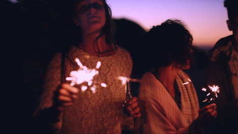 friends celebrating sunset with sparkler